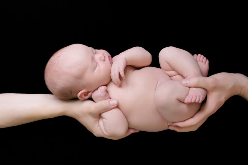 Parents hands holding newborn baby | san diego newborn photography | Visit www.babiesandbeauties.com