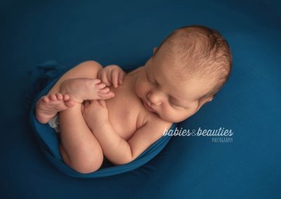 Newborn baby wrapped up in blue wrap | newborn photography san diego | Visit www.babiesandbeauties.com to learn more!