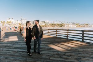 Newly engaged couple walking hand in hand on Oceanside pier